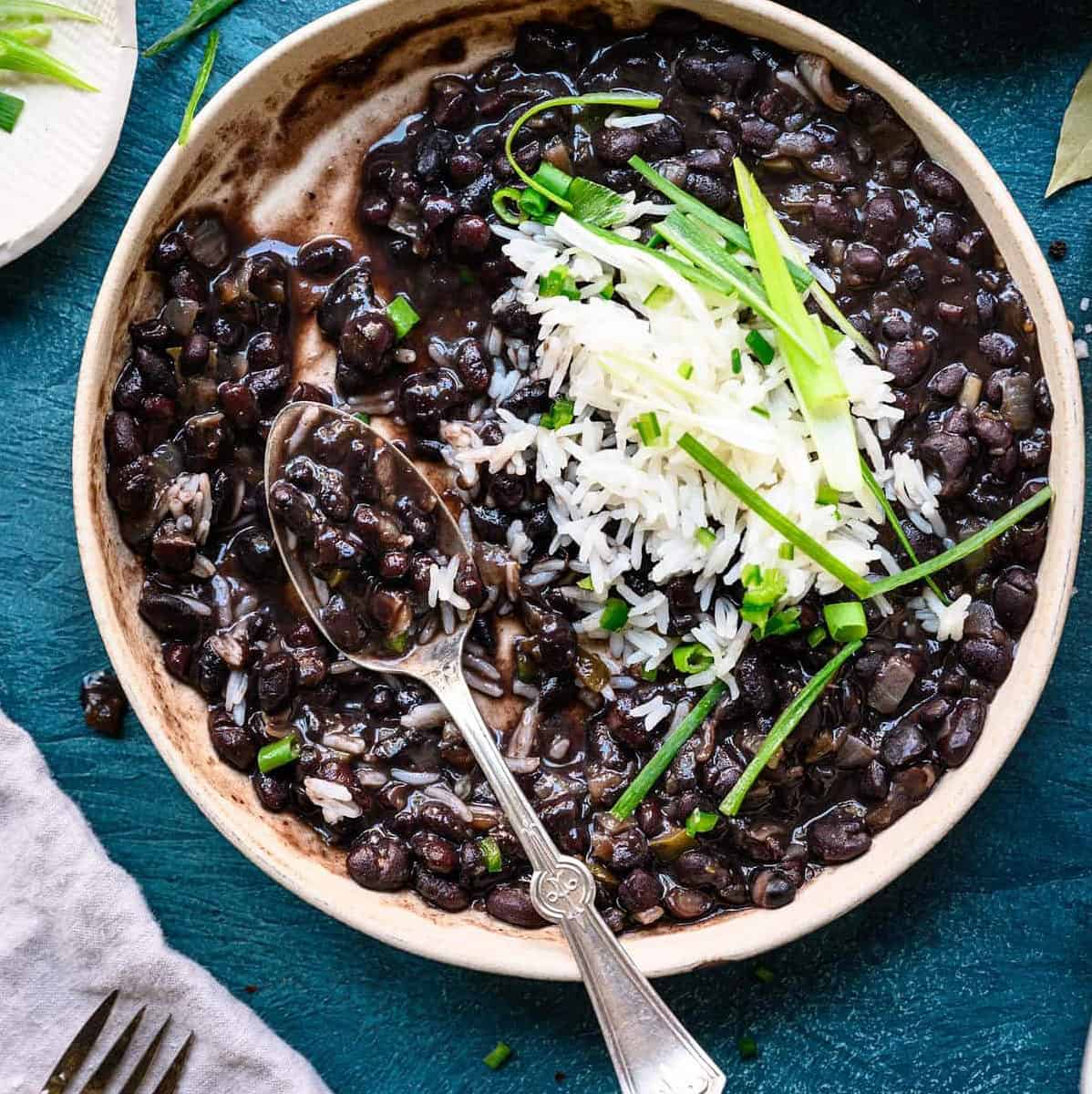  A warm bowl of vegan Cuban black beans, garnished with fresh cilantro and a squeeze of lime.